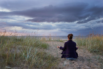 Naklejka na ściany i meble Woman meditate at the sea