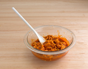 Bowl of canned pasta lasagna with spoon on table