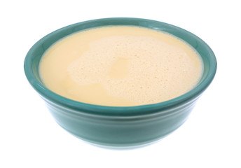 Bowl of evaporated milk on a white background.