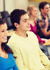 group of smiling students in lecture hall