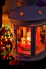 Christmas lantern with wax running down on the background of lights