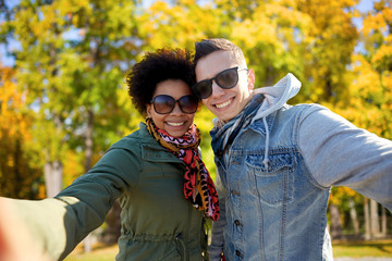 Fototapeta premium happy teenage couple taking selfie on city street
