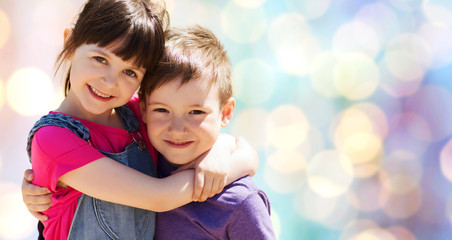 two happy kids hugging over blue lights background