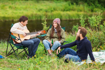 group of tourists playing guitar in camping