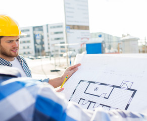 close up of builders with blueprint at building