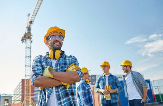 group of smiling builders in hardhats outdoors