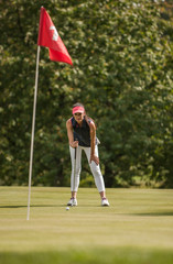 Nice woman surveying her putt on the fourteenth hole.