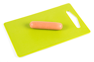 raw sausage on a green cutting board isolated on a white background