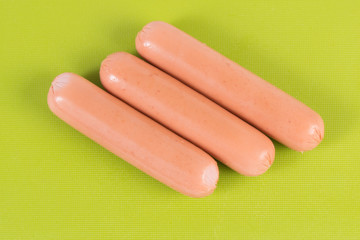 raw sausage on a green cutting board isolated on a white background