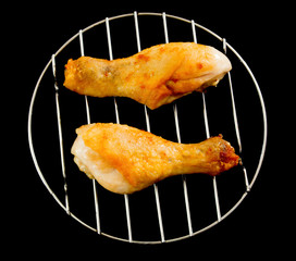 chicken legs on the grill view from above up isolated on black background