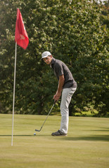 Fototapeta premium Portrait of a middle aged man playing golf on a nice course.