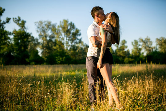 Happy Young Couple in nature fun.Family Outdoors. love kiss