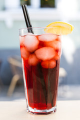 Strawberry lemonade with ice in glass on wooden background