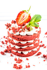 Delicious red cake with cream and berries close up.