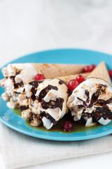 Ice cream with honey and red berries on blue plate