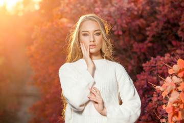 young woman on a background of red and yellow autumn leaves with