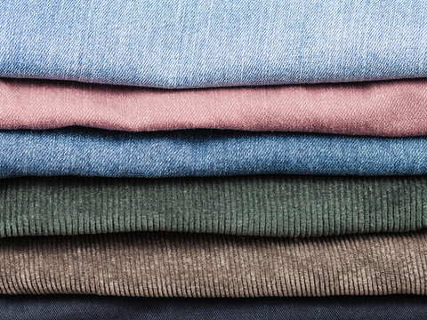 stack of various jeans and corduroy slacks