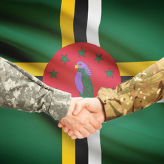 Men in uniform shaking hands with flag on background - Dominica