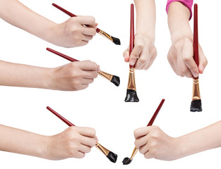 set of hands with art paintbrushes with black tips