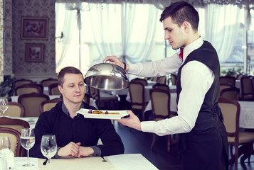 young man having dinner in a restaurant