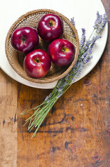 bouquet of lavender and red apples on a wooden background