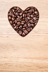 Heart shaped coffee beans on wooden board