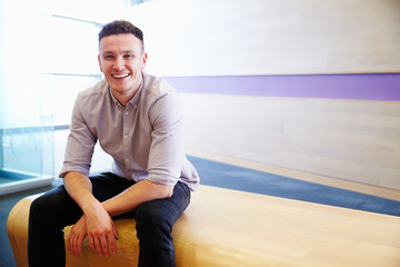 Portrait of young Caucasian man sitting, looking to camera