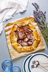 Healthy open apple pie with lavender. French cuisine on grey