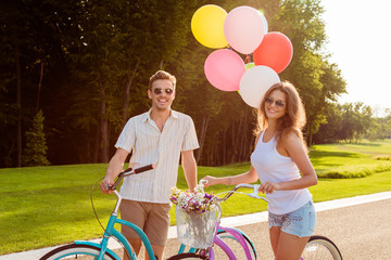 couple in love on bikes with balloons and flowers