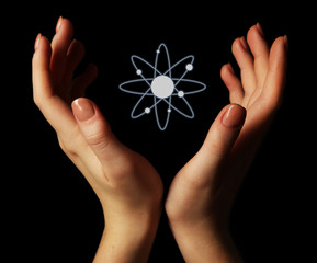 Hands with atom image, on black background