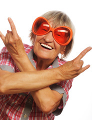 Senior woman wearing big sunglasses doing funky action 