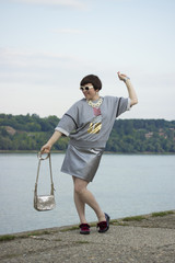 Fashion blogger posing, ecletic style. Metalic, gray colors.