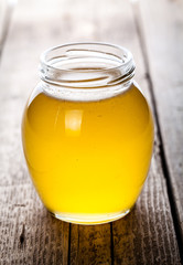 Bowl of honey on wooden table. 