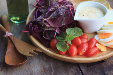 fresh red spinach salad and cream on wooden table
