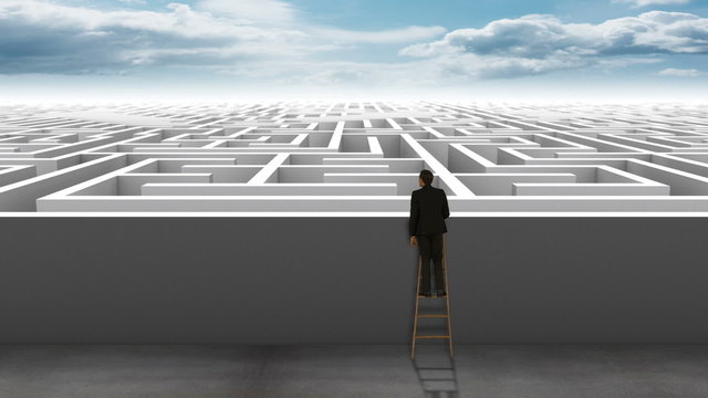Businessman on ladder looking at maze