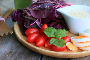 fresh red spinach salad and cream on wooden table