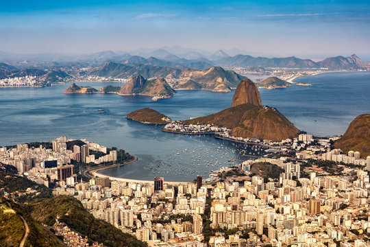 Spectacular aerial view over Rio de Janeiro as viewed from Corcovado. The famous Sugar Loaf mountain sticks out of Guanabara Bay