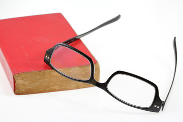 Red book and eyesglass on white background