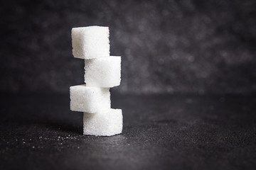 cloose up white sugar cubes on black stone plate background