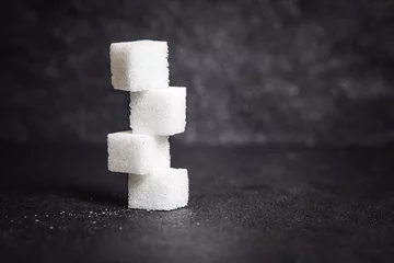 Foto op Plexiglas cloose up white sugar cubes on black stone plate background © Cozine