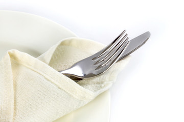 close up dinning silverware fork and knife with dish on white ba