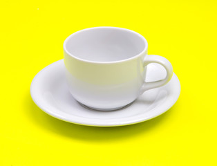 empty white coffee or tea cup on vibrant yellow color background