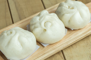 Fototapeta na wymiar White Steamed buns on wooden tray
