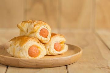 Danish Pastry with sausage on wooden dish