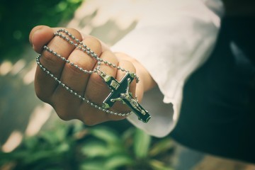 Hands praying with cross