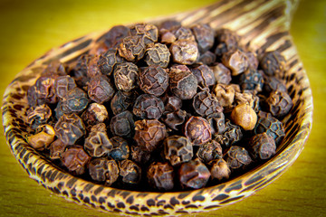 Black pepper in wooden spoon