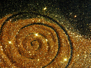 Blurry golden spiral of glitter sparkle on black background like a star galaxy