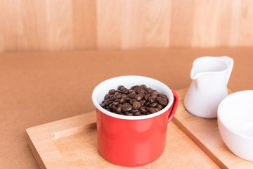Vintage red coffee cup and roasted beans on old wood background
