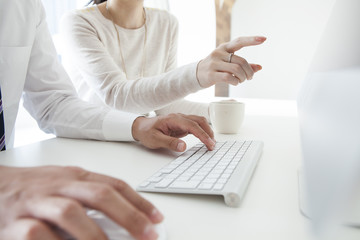 Men are entering the keyboard,Woman pointing finger monitor