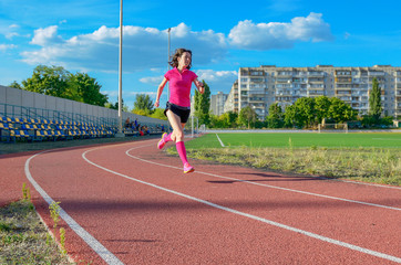 Obraz premium Happy active woman running on track, sprinting and working out on stadium 